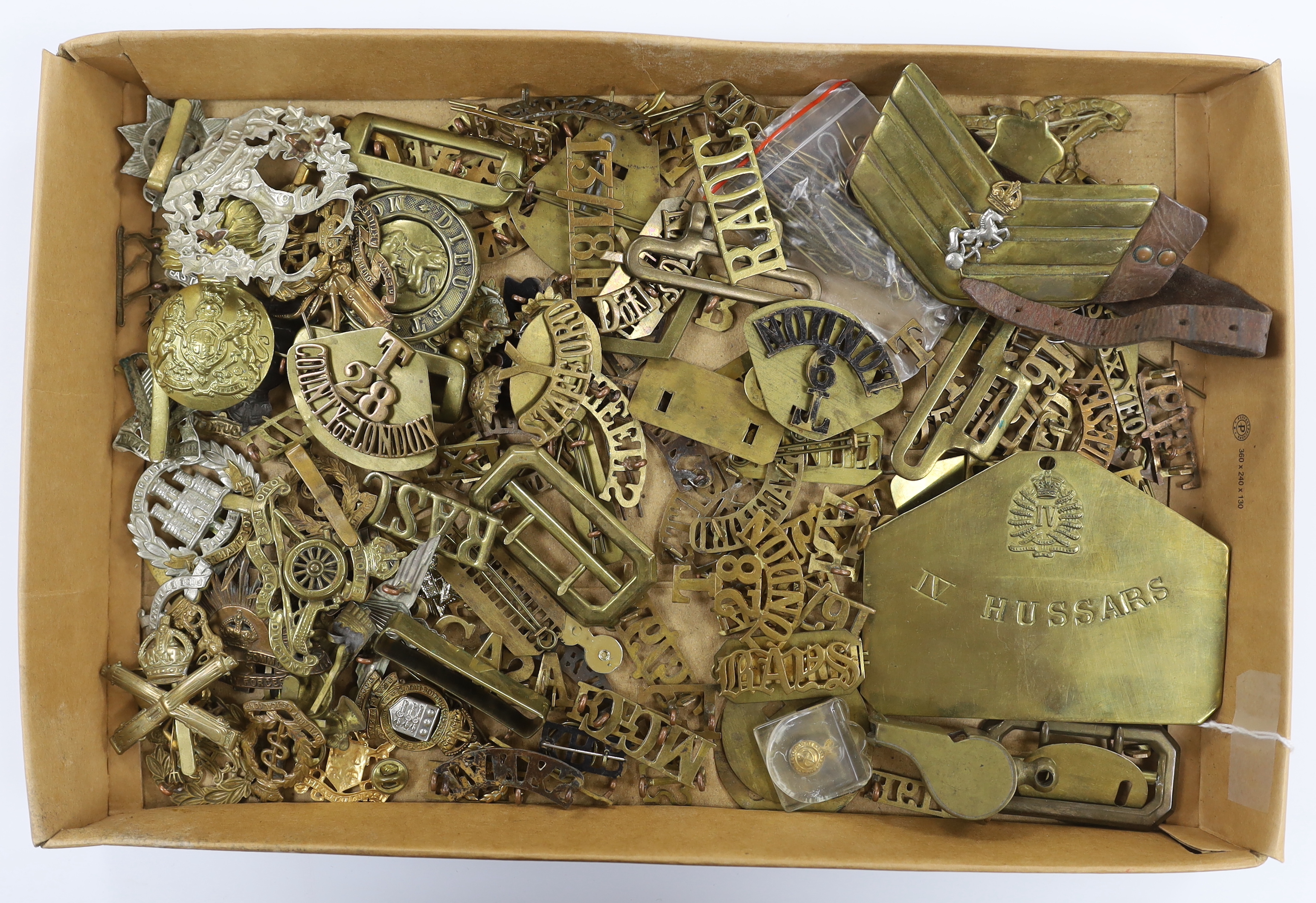 A collection of military cap badges, shoulder titles, pins, backing plates, belt buckles, etc.